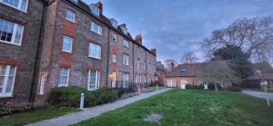 a large brick building with a grass yard in front of it at Luxury flat next to town centre Long-stay discount in Reading