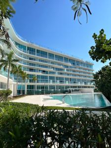 ein großes Gebäude mit einem Pool davor in der Unterkunft Marítima Golf Luxury Department 2BR in Bucerías