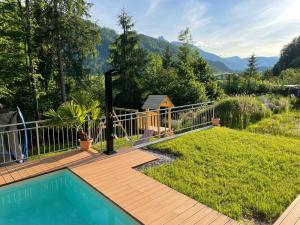 a backyard with a wooden deck and a swimming pool at Salzkammergut View in St. Wolfgang