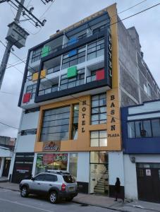 帕斯托Hotel Basan Plaza的一栋建筑前停着一辆车
