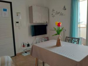 una mesa con un jarrón con una flor. en La casa di Steno, en Lecce