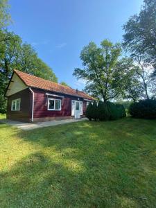 a small red house with a large grass yard at Morning Glory, Huisje vogelzang in Beekbergen