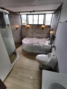 uma casa de banho com uma banheira, um WC e um lavatório. em Hotel Basan Plaza em Pasto