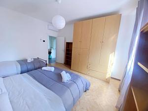 een slaapkamer met een groot blauw bed en houten kasten bij Giulia home in Monfalcone