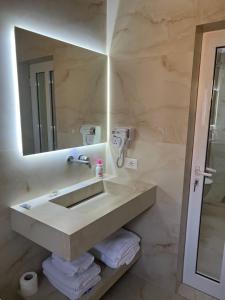 a bathroom with a sink and a mirror at Apartments Rezidenca Sinani Orikum in Orikum