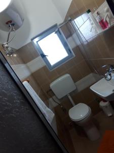 Hotel Beso في Këlcyrë: حمام صغير مع مرحاض ونافذة