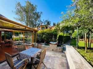 eine Terrasse mit einem Tisch und einigen Stühlen in der Unterkunft Villa Verde Piran, Authentic Mediterranean Stay in Piran