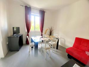 een woonkamer met een tafel en een rode bank bij Giulia home in Monfalcone