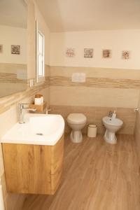 a bathroom with a sink and a toilet at Su Hantaru Vetzu in Mamoiada +21 photos