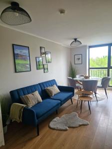 a living room with a blue couch and a table at Луксозен Апартамент в Модерна сграда -Молимаркс Делукс Апартамент Бургас in Burgas City
