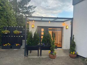 ein Haus mit Topfpflanzen und einem Tisch davor in der Unterkunft Ferienwohnung E in Soltau