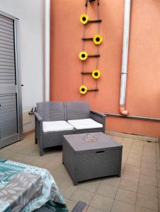 un patio con una silla y girasoles en la pared en La casa di Steno en Lecce