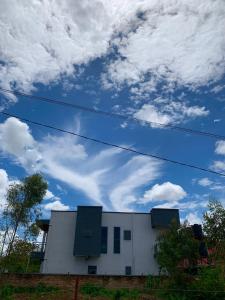 ein weißes Gebäude mit blauem Himmel und Wolken in der Unterkunft KWETU HAVEN HOMES in Kigali