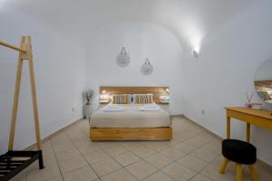 a bedroom with a bed in a white room at AngelEve Villa with private Jacuzzi in Fira