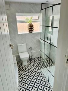 a bathroom with a toilet and a potted plant at Superbly located terraced house in Manchester