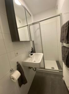 ein weißes Badezimmer mit einem Waschbecken und einem Spiegel in der Unterkunft Walle Retreat Zentral&Gemütlich in Bremen