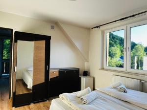 a bedroom with two beds and a large window at Nad Grajcarkiem - Pensjonat in Szczawnica