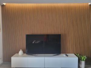 a flat screen tv sitting on top of a white cabinet at Eagle Vacation Home in Palm-Eagle Beach