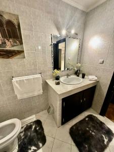 a bathroom with a sink and a toilet and a mirror at Le Vélodrome au cœur de Casablanca in Casablanca