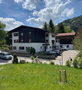 ein Gebäude mit Menschen, die auf einem Parkplatz Fahrrad fahren in der Unterkunft Ferienwohnung Tiefenbach mit Garten in Oberstdorf