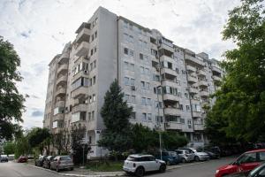 een groot appartementencomplex met auto's geparkeerd op een parkeerplaats bij Belgrade Apartment Nook 1 in Belgrado