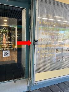 a red arrow pointing into a window of a store at Kumpukuja apartment in Kouvola