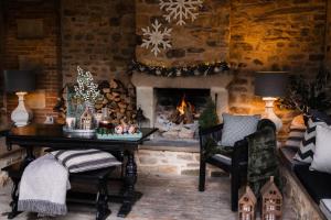 a living room with a fireplace and a table and a chair at Easby Hall in Richmond