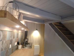 een keuken met een trap en een wastafel in een kamer bij la grange aux oiseaux in Arnaville