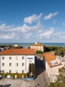 a view of a building with the ocean in the background at Hotel Nina in Marina di Bibbona