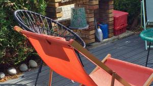 uma cadeira laranja sentada num deque em Sun House - Terrasse Parking Privé gratuit em Troyes