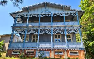 a large building with a blue roof at Villa Loebel - One bedroom apartment with balcony in Juodkrantė