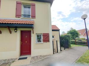 a house with a red door and a fence at Entre terre et mer in Camiers