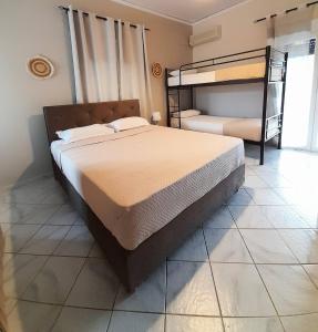 a bedroom with two bunk beds and a tiled floor at Aggeliki Apartments in Nikiana