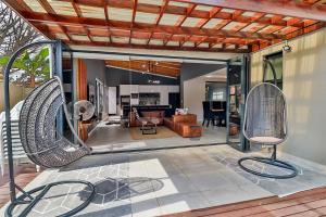 a patio with two chairs and a living room at House of Bongekile 4 Bed Luxury Home in Malelane in Malelane