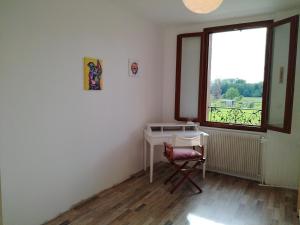 een kamer met een bureau, een raam en een stoel bij Au gîte Sérénité in Mouthier-en-Bresse