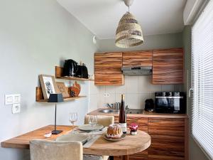 a kitchen with a wooden table with chairs and a dining room at Le Studio des Vignes in Eguisheim