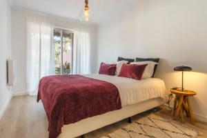 biała sypialnia z dużym łóżkiem z czerwonymi poduszkami w obiekcie Sun e Sea Golf House w mieście Aroeira