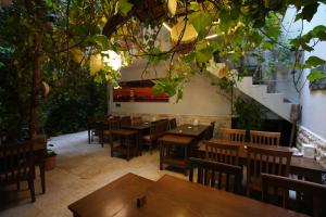 a restaurant with wooden tables and chairs and trees at OzenTurku Hotel in Pamukkale