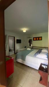 a bedroom with a large bed and a television at Chez Max Pousada in Morro de São Paulo