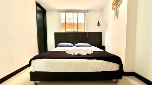 ein Schlafzimmer mit einem großen Bett mit einer braunen Decke in der Unterkunft Apto Moderno en Laureles in Medellín