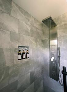 Exclusive Waterfront Cottage في Combermere: حمام به دش وبه بلاط رمادي