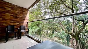 einen Balkon mit 2 Stühlen und einem großen Fenster in der Unterkunft Apto Moderno en Laureles in Medellín