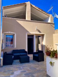 un patio con divani blu e un edificio di Wellhouse a SantʼAntìoco