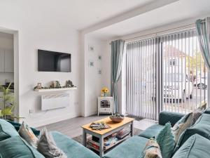 uma sala de estar com um sofá azul e uma grande janela em Mary Bowes Terrace em Bournemouth