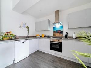 a white kitchen with white cabinets and a sink at Mary Bowes Terrace in Bournemouth