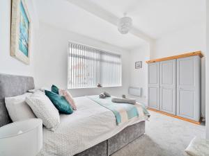 een witte slaapkamer met een bed en een raam bij Mary Bowes Terrace in Bournemouth