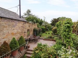 an external view of a garden with a stone building at The Book House in Warkworth