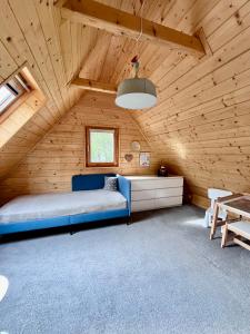 a bedroom with a blue bed in a wooden room at Chalúpka in Stará Ľubovňa