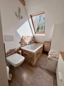 a bathroom with a tub and a toilet and a window at Chalúpka in Stará Ľubovňa +28 photos