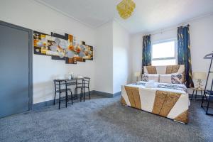 a bedroom with a bed and a table with chairs at -RE7H- For your relaxed & Cosy Free Parking in Leeds